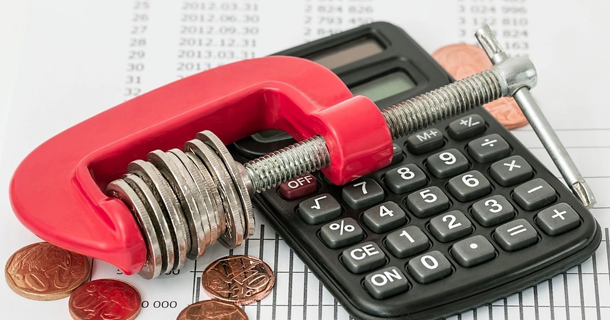 آلة حاسبة وعملات نقدية فوق كشف حساب